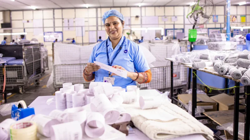 Tekstil üretiminde basılı ürün etiketlerini kontrol eden fabrika çalışanı.
